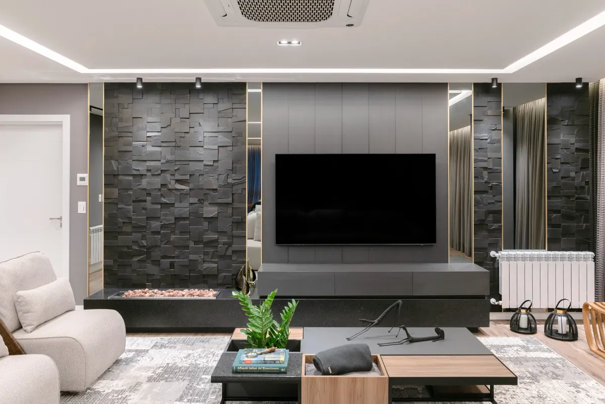 Sala contemporânea com painel de televisão e revestimento em pedra escura